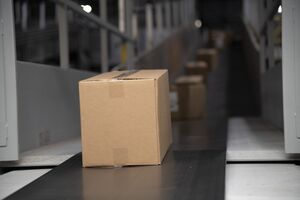 a cardboard box on a conveyor belt. Photo.